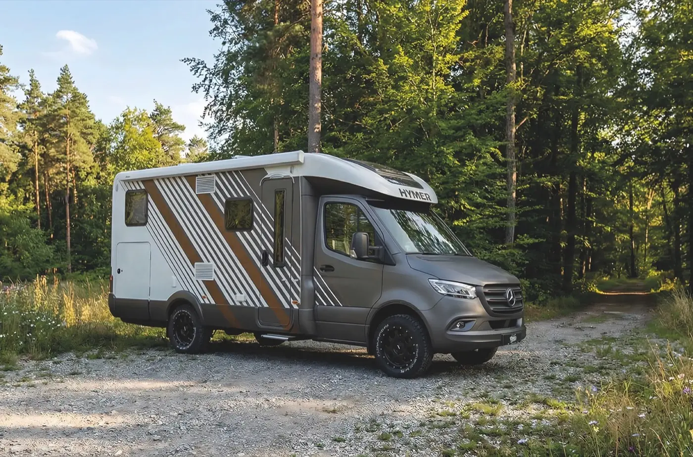 Hymer-Wohnmobil mit gestreifter Camper-Folierung im Wald