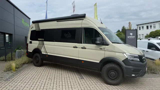 MAN TGE Camper-Van in Sandbeige mit schwarzer Fensterfläche und Streifen-Design
