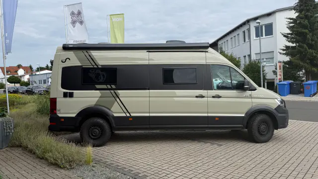 MAN TGE 4x4 Camper mit Streifen-Folierung in Beige und Schwarz – Seitenansicht
