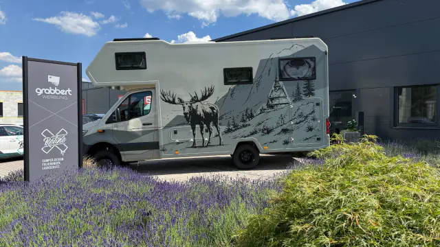 Alkoven-Wohnmobil mit Elch- und Stabkirchen-Motiv im Skizzenstil